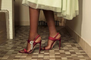 woman wearing burgundy  heels in tiled bathroom
