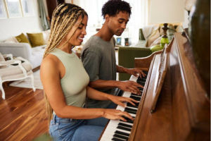 young couple playing piano in living room