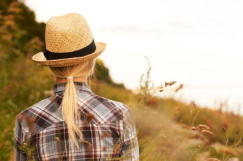 Woman wearing wholesale hat fedora on grassy hill
