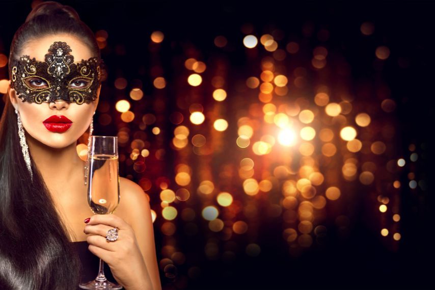 beautiful woman in masquerade mask with champagne
