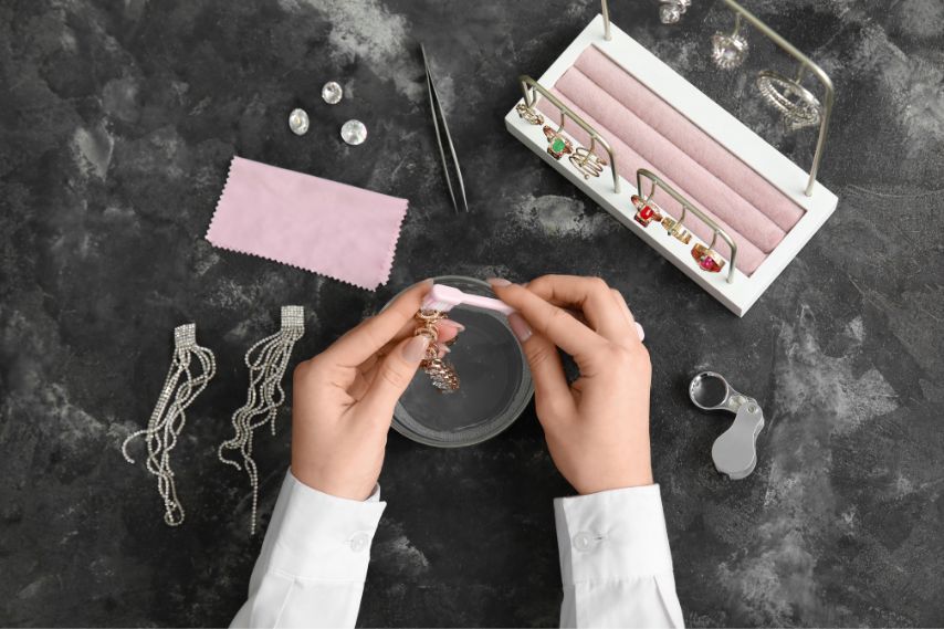 woman cleaning wholesale jewelry on black background