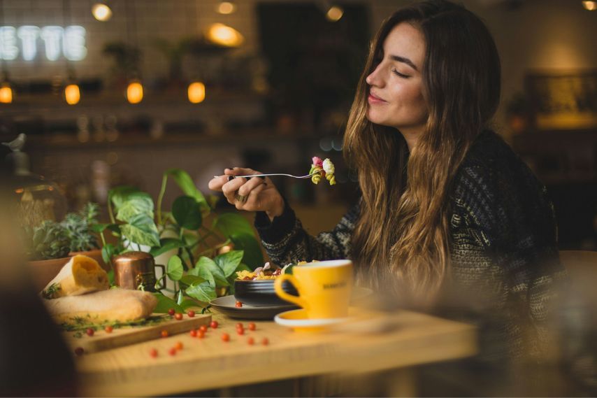 woman holding fork in front table eating healthy