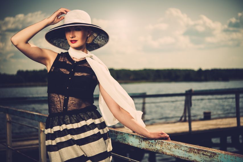 Beautiful woman wearing hat and scarf on pier