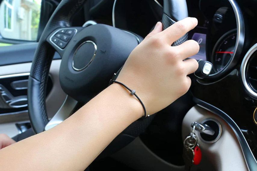 Person wearing GTFO Wrist Strap driving car