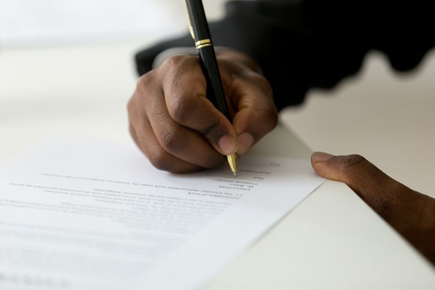 black mans hands signing paperwork